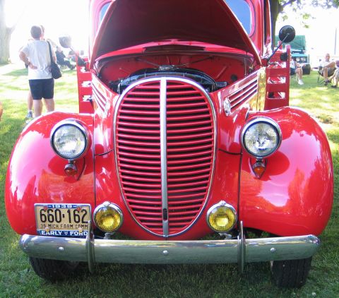 1994 Ford Bronco - A vintage red Ford truck is displayed with its hood open, revealing the engine and front grille.