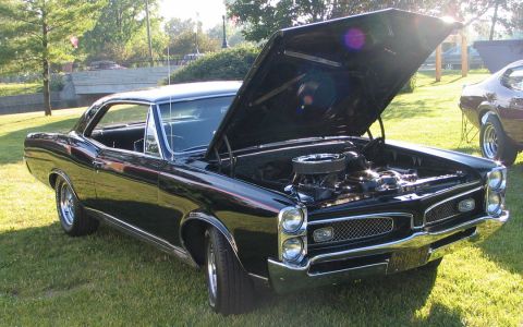 1994 Ford Bronco - Black 1967 Pontiac GTO coupe at a car show, hood raised to display the engine.