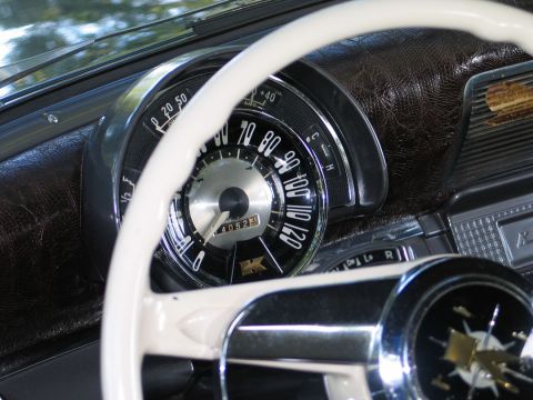 1994 Ford Bronco - Close-up of a vintage car's dashboard, a white steering wheel and a prominent speedometer.