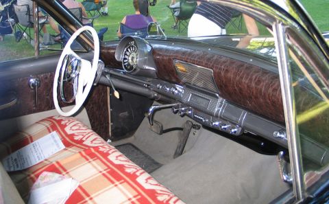 1994 Ford Bronco - Interior view of a classic car with a distinctive dashboard and steering wheel, seen at an outdoor event.