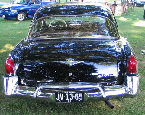 1994 Ford Bronco - Rear view of a black sedan with a Michigan license plate dated 1953 and 1965.