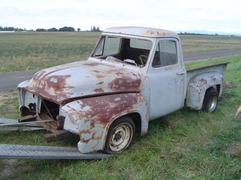 1955 Ford F-100 - A weathered and rusty 1953 Ford F-100 pickup truck is being transported on a trailer.