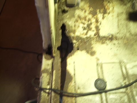 1979 Ford F-150 - The interior floor of a vehicle shows significant staining and damage, with visible wiring.