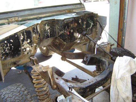 1971 Ford Bronco - Close-up of vehicle frame and suspension system during a tear-down or repair process.