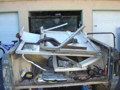 1971 Ford Bronco - The interior of a vehicle has been completely disassembled and is piled up in the cargo area.