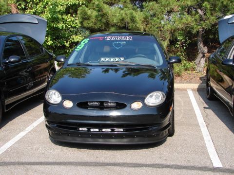 1992 Ford Taurus - Black Ford Taurus parked in a lot, a Yamaha sticker on the windshield.