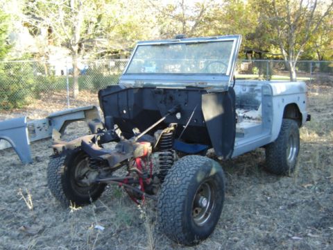 1971 Ford Bronco - A disassembled 1971 Ford Bronco sits in a grassy yard, awaiting restoration.