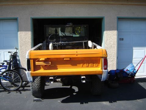 1971 Ford Bronco - Rear view of an orange 1971 Ford Bronco, showing the tailgate area with the vehicle's name embossed.