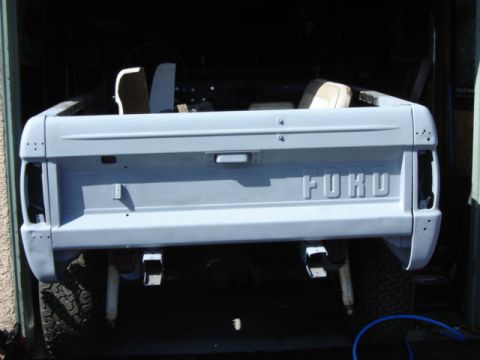 1971 Ford Bronco - The rear of a classic Ford Bronco, prepped for paint, shows the iconic embossed lettering and tailgate handle.