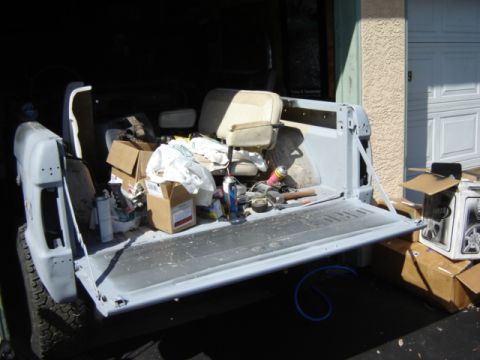 1971 Ford Bronco - The rear of a 1978 Ford Bronco is shown with the tailgate down, containing various items.
