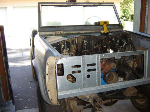 1971 Ford Bronco - The front clip of a 1971 Ford Bronco is shown during a repair process, with the engine bay exposed.