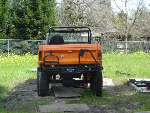 1971 Ford Bronco - Rear view of an orange 1971 Ford Bronco, a custom bumper and spare tire carrier.