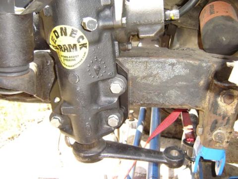 1971 Ford Bronco - Close-up of a vehicle's steering box and linkage, a yellow sticker with product information.