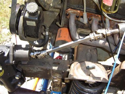 1971 Ford Bronco - Close-up view of the steering column universal joint and power steering reservoir in an engine bay.