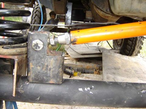 1971 Ford Bronco - Close-up view of vehicle suspension components, including coil springs and a track bar, with visible rust and wear.