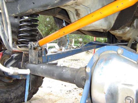 1971 Ford Bronco - Undercarriage view of a vehicle's rear axle and suspension system, with another vehicle visible in the background.