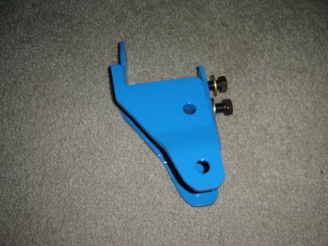 1971 Ford Bronco - A blue metal bracket with bolts is shown against a carpeted background, likely a vehicle part.