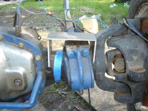1971 Ford Bronco - Close-up view of a vehicle's front axle assembly, showing the U-joint and a blue differential cover.