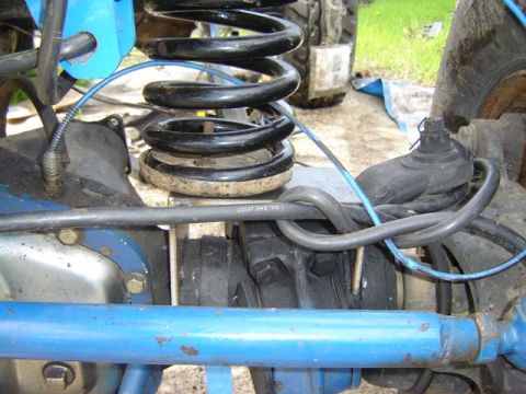 1971 Ford Bronco - This image shows a close-up view of the suspension system of a vehicle, focusing on the axle and springs.