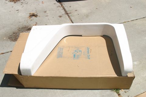 1971 Ford Bronco - A white fender flare sits on a cardboard box outdoors.