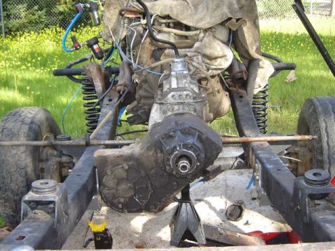 1971 Ford Bronco - Vehicle frame with engine and transmission assembly on jack stands, showing suspension and tires.