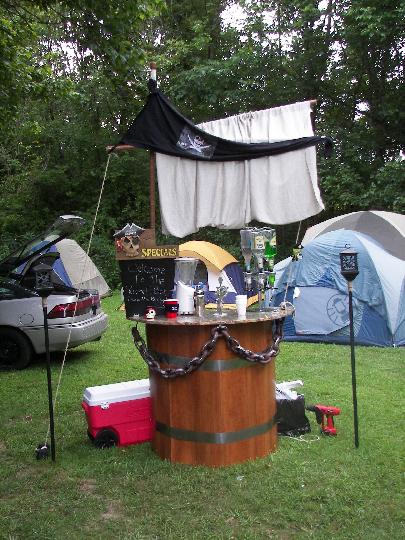 1995 Ford Probe - An outdoor scene with a car, a bar, and tents set up on a grassy area.