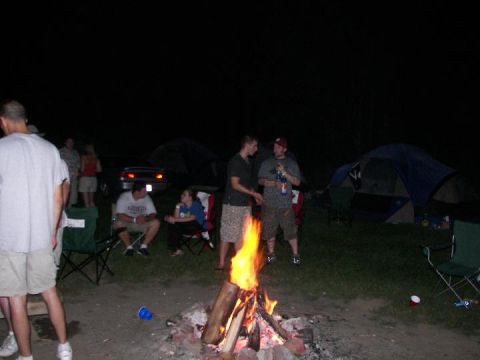 1995 Ford Probe - A group of friends enjoy a campfire at a campsite with tents visible in the dark.