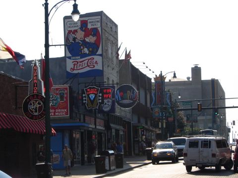 1992 Ford Taurus - A street scene in Memphis features various businesses with prominent signage and vehicles navigating the road.