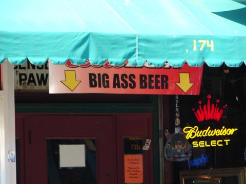 1992 Ford Taurus - A storefront features a 'BIG ASS BEER' sign and a Budweiser Select neon sign under a turquoise awning.
