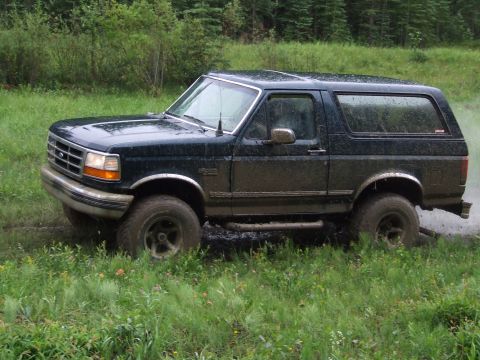 1990 Ford Bronco - Muddy 1990 Ford Bronco navigating off-road conditions.