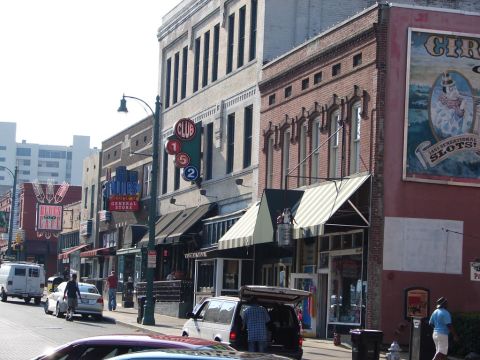 1992 Ford Taurus - A street scene captures various vehicles and storefronts along a city block.
