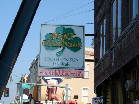 1992 Ford Taurus - A sign for Silky O'Sullivan's advertises food, music, and fun with a shamrock logo and a picture of a beer.