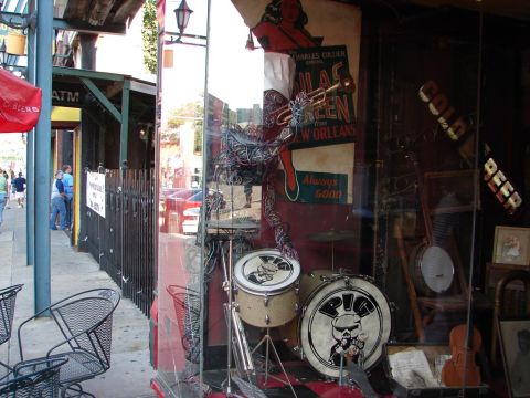 1992 Ford Taurus - A storefront window displays musical instruments and posters, with a street scene visible through the glass.
