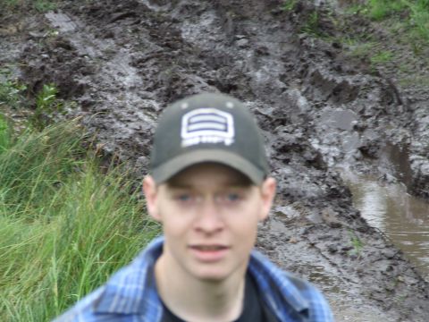 1990 Ford Bronco - A person stands in front of a muddy, wet area with tall grass.