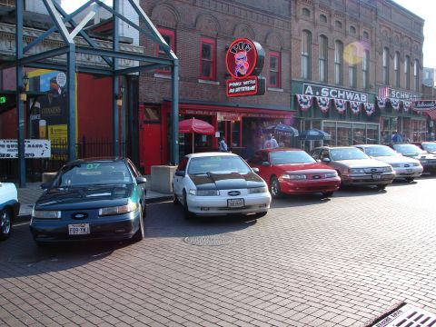 1992 Ford Taurus - Several Ford Tauruses are lined up on a street in front of brick buildings.