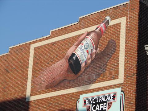 1992 Ford Taurus - Mural of a hand holding a Budweiser bottle on a brick building wall, with a sign for King's Palace Cafe below.