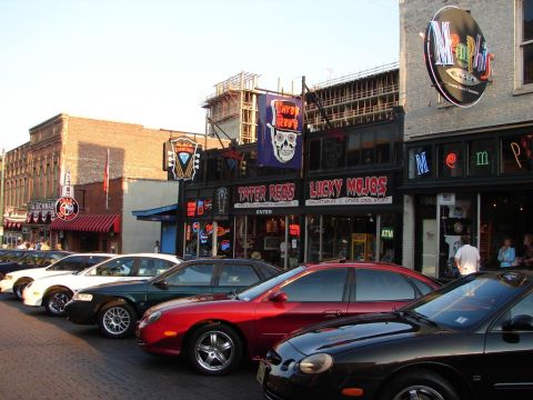 1992 Ford Taurus - Street view with several cars parked in front of shops including Tater Reds and Lucky Mojos.