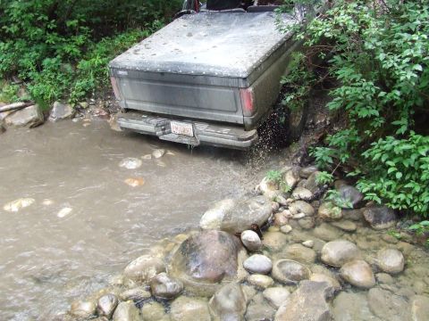 1990 Ford Bronco - 1990 Ford Bronco navigating a rocky creek bed during an off-road excursion.