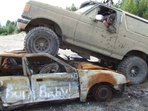 1990 Ford Bronco - A 1987 Ford Bronco crushes a destroyed sedan, which has graffiti on its doors.