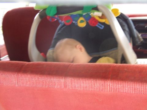 1990 Ford Bronco - Baby sleeping in a car seat with a toy arch overhead.