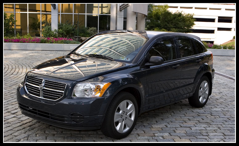 Front three-quarter of a dark blue Dodge Caliber on cobblestone with crosshair grille