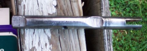 1978 Ford Bronco - A metal lever with a split end is shown resting on weathered wood planks.
