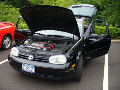 1991 Ford Probe - A black Volkswagen Golf GTI is parked with its hood and doors open, revealing the engine bay.