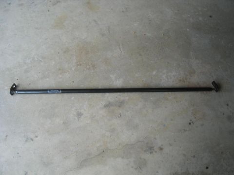 1993 Ford Probe - Strut bar with visible text on the bar itself, placed on a concrete surface.