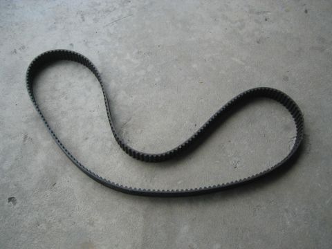 1993 Ford Probe - A black timing belt lies on a gray concrete surface.