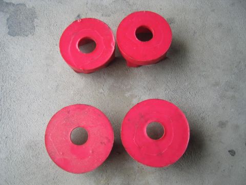 1993 Ford Probe - Four red polyurethane bushings are shown on a gray concrete surface. The image includes a SuperMotors watermark.