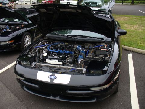 1991 Ford Probe - Two black Ford Probes are parked side-by-side with their hoods open, revealing their engines.