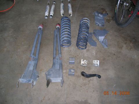1985 Ford Bronco - Various suspension parts and shocks are displayed on the floor, possibly for a vehicle repair or upgrade.