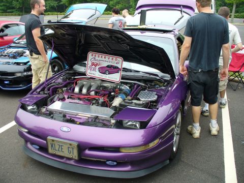 1991 Ford Probe - A purple 1994 Ford Probe GT is displayed with its hood open, revealing a customized engine bay and a reserved sign.