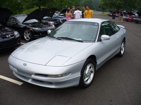 1991 Ford Probe - A silver 1991 Ford Probe is displayed at an outdoor event with several other vehicles visible.